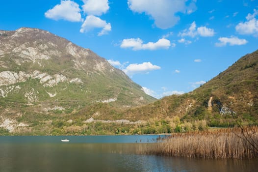 Landscape of lake, mountains and clouds in blue sky.