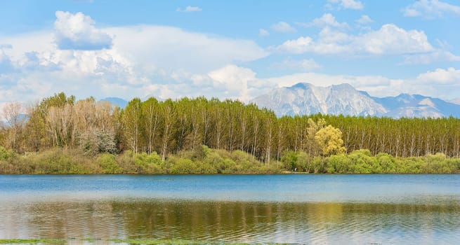 Landscape of lake, mountains and clouds in blue sky.