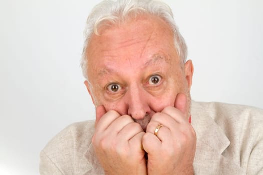 Senior holds hands in front of his mouth - on a bright background