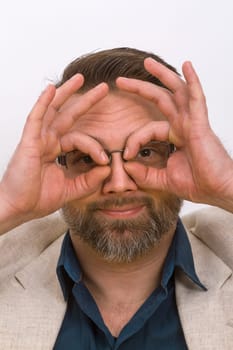 Man holds finger after eyes on a bright background