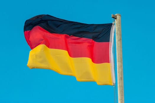 Waving flag of Germany with blue background