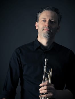 Dark portrait of a musician with a brass instrument