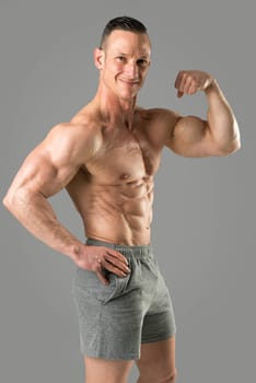 Powerful athletic man with great physique. Strong bodybuilder showing his biceps.