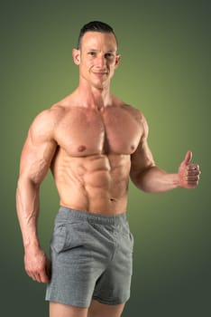Powerful athletic man with great physique. Strong bodybuilder with six pack, perfect abs, shoulders, biceps, triceps and chest.