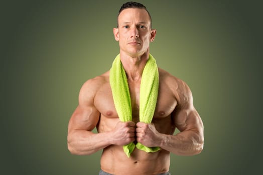 Powerful athletic man with great physique holding a towel.
