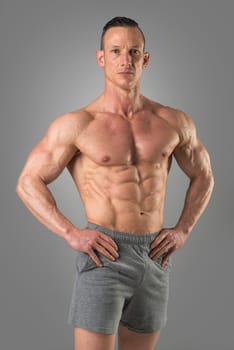 Powerful athletic man with great physique. Strong bodybuilder with six pack, perfect abs, shoulders, biceps, triceps and chest.