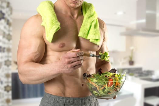 Powerful athletic man with great physique eating a healthy salad.