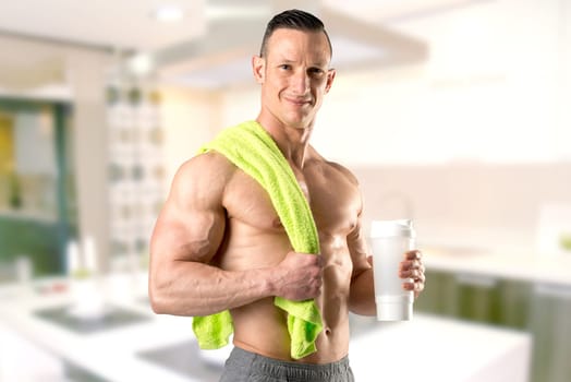 Powerful athletic man with great physique holding a gym bottle