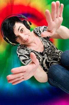 Colored upper body view of a black-haired middle-aged woman with headphones colorfully colored against a white background.