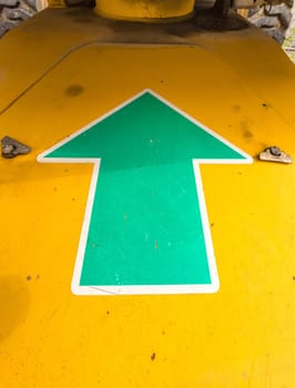 Green arrow pointing upwards on a machine
