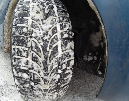 Close up of winter tire on snowy road.
