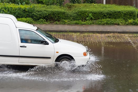 car drives through a flooded street