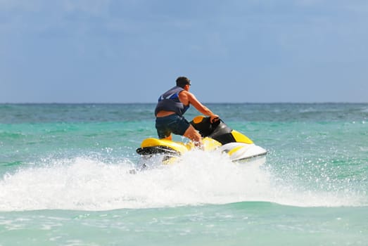 Man on Wave Runner turns fast on the water