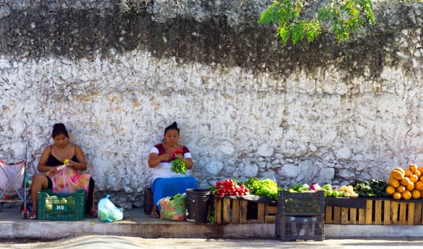 VALLODLID, MEXICO - FEBRUARY 11: Two women sell fruit and vegetables on the sidewalk in Valladolid, Mexico on February 11, 2017