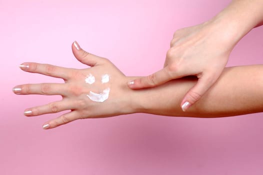 Hand shows to another hand where is smiley from hand cream. Skincare concept.