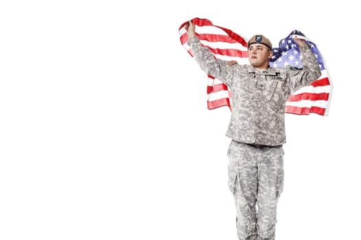 Army Ranger from Special Troops Battalion in universal Camouflage pattern Uniforms and Tan beret with Ranger Regiment crest standing and holding waving US flag in his hands proudly. National holidays: Veterans Day, Memorial Day