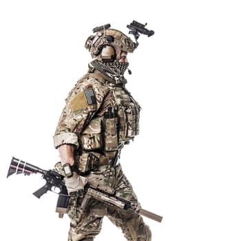 Army Ranger in field Uniforms with weapon, plate carrier and combat helmet are on, his face closed by Shemagh Kufiya scarf. Studio shot