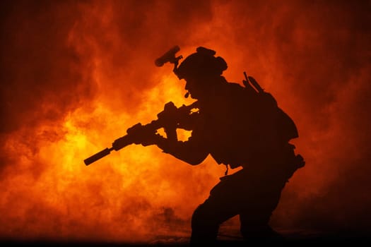 Black silhouettes of soldier in the smoke fire burning moving in battle operation. Back light