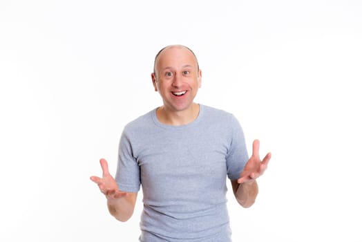 young baldheaded with open hands man in front of white background looking surprised