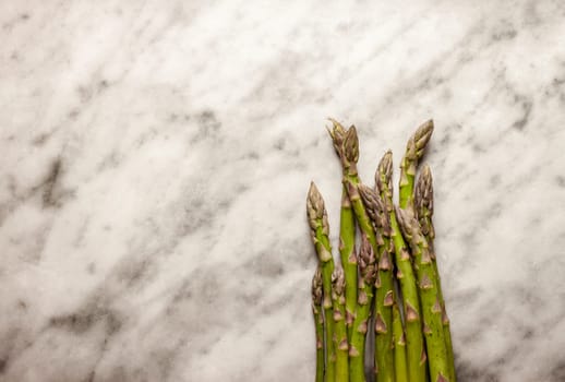 fresh green asparagus on white marble background with free space