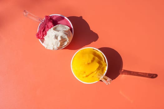 bright delicious ice cream in paper cups on orange table