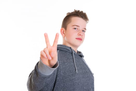 teenager in front of white background showing victory sign