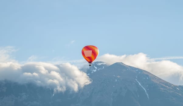 colorful air ballon aerostat flying over clouds and mountains