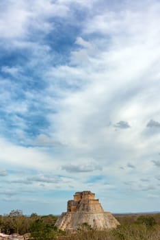 Vertical view of the House of the Magician in Uxmal, Mexico with a dramatic sky