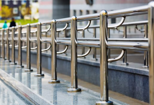 Chromium metal fence with handrail. Metal railings. Shallow depth of field. Selective focus.
