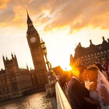 London, UK - April 2, 2015: People on Westminster Bridge in sunset on 2th of April, 2017 in London. Big ben and Palace of Westminster aka Houses of Parliament in background.