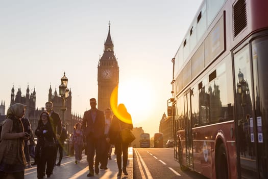 London, UK - April 7, 2017: Traffic and pedestrians passing on Westminster Bridge in sunset on 7th of April, 2017 in London. Big ben and Palace of Westminster aka Houses of Parliament in background.