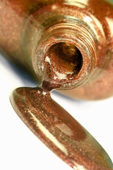 The spilled brown nail polish is on white background.