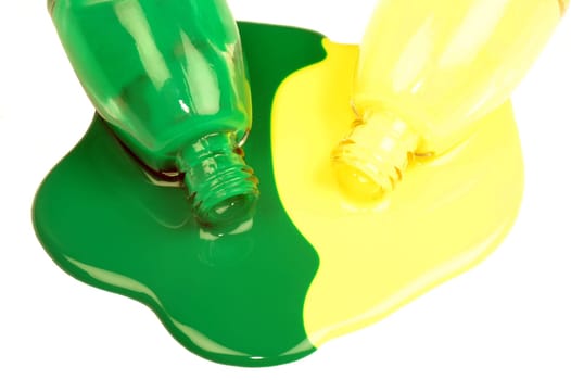 The spilled green and yellow nail polishes are on white background.