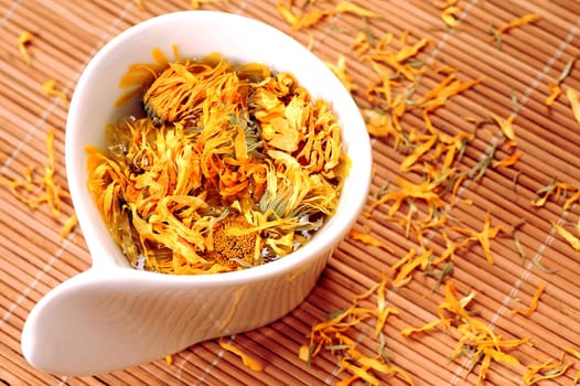 Tea made from marigold is in white cup.