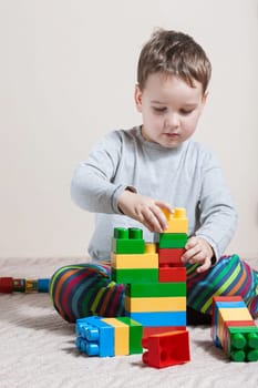 Playing little boy with colored cubes