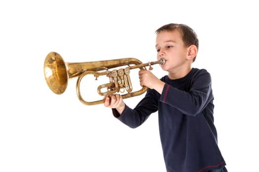 young boy blowing into a trumpet against white background