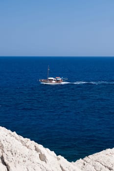 Kolymbia beach with the rocky coast in Greece. Motorboat and speed  in blue sea.