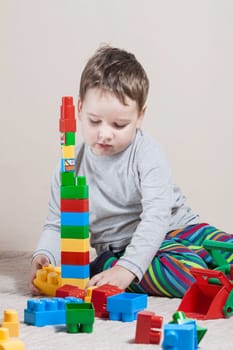 Playing little boy with colored cubes