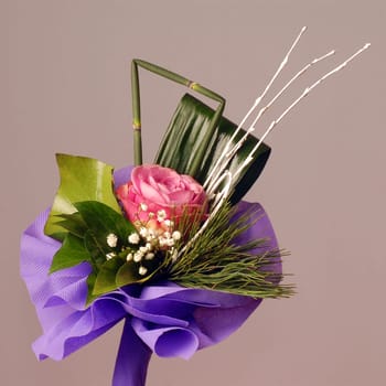 Bouquet with pink rose on gray background.