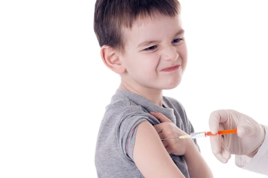 Doctor giving a child injection in arm on isolated image.