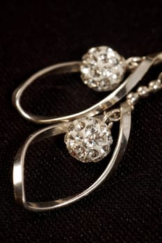 The silver earrings are on black background.