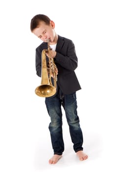 young boy blowing into a trumpet against white background