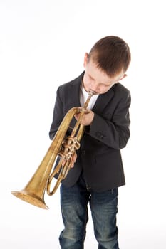 young boy blowing into a trumpet against white background