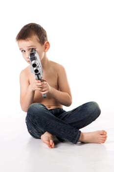 young boy blowing into a trumpet against white background
