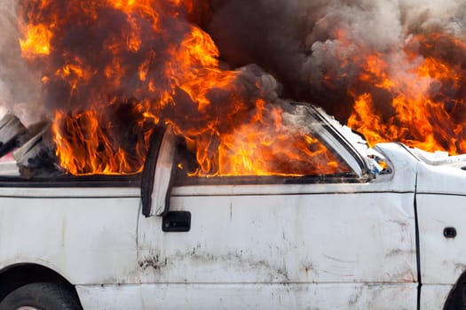 burning and then extinguish an old white car - Exercise firefighters