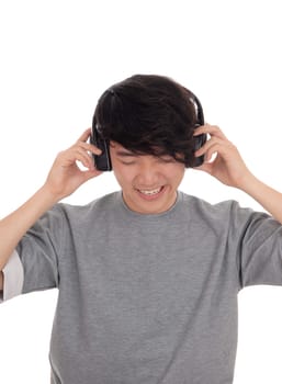 A young handsome Korean teenager listen to music with his headset,.in a gray t-shirt, isolated for white background..