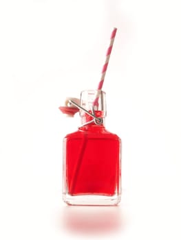 Red juice with paper straw on a white background