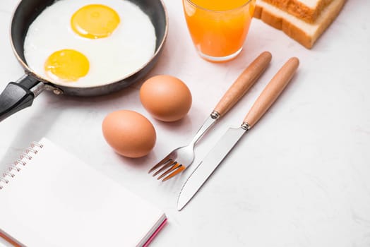 Top view of traditional healthy easy quick breakfast meal made of fried eggs served on a frying pan.