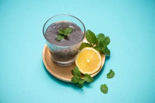 Selective focus of chia seeds drink with water in transparent glass with lemon balm.