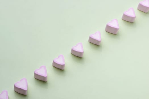 Valentines Day candy hearts marshmallows over green background